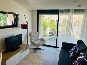 a living room with a couch and a tv and a chair at Gîte en Provence in Mison