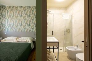 a bedroom with a bed and a bathroom with a shower at Salvia Hotel in Poggio Moiano