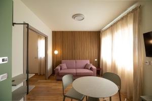 a living room with a table and a pink couch at Salvia Hotel in Poggio Moiano