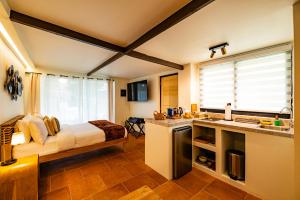 a bedroom with a bed and a kitchen with a sink at Esensia Boutique Studio in Oranjestad