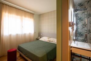 a small bedroom with a bed and a sink at Salvia Hotel in Poggio Moiano +2 photos