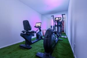 a gym with treadmills and exercise bikes in a room at Chill Villa - Signature by Paradise Portugal in Mariquiteira +58 photos