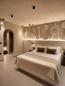 a bedroom with a large bed with a large painting on the wall at Ethos Suites in Agios Prokopios