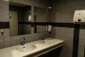 a bathroom with two sinks and a mirror at Budget Hostel De Elderschans in Aardenburg +19 photos