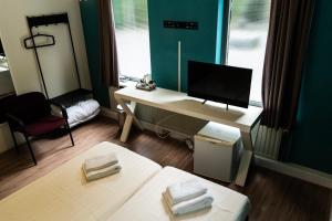 a room with a desk with a computer and a bed at Budget Hostel De Elderschans in Aardenburg
