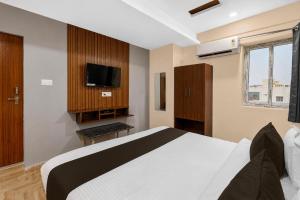 a bedroom with a large bed and a tv at Hotel O R Eleven in Hyderabad