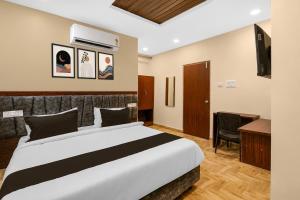 a hotel room with a bed and a desk at Hotel O R Eleven in Hyderabad