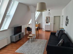 a living room with a couch and a table at Zentrales Dachgeschoss-Apartment Bielefeld in Bielefeld