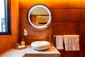 a bathroom with a large sink and a mirror at Esensia Boutique Studio in Oranjestad +18 photos