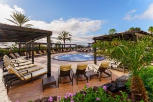 a patio with chairs and a swimming pool at Occidental Jandía Royal Level - Adults Only in Morro del Jable