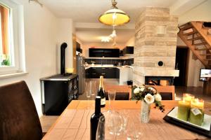 a kitchen and dining room with a table with wine bottles at Villa Suzana's Nature Hideout in Gospić