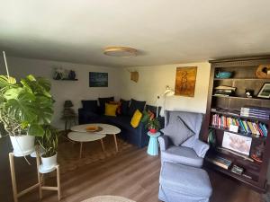 a living room with a blue couch and a table at Lauenhainer Alm in Mittweida