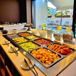 a buffet with many trays of different fruits and vegetables at Valmar Hotel in Ksamil