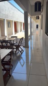 a hallway with tables and chairs in a building at Hotel AD Cassilândia in Cassilândia