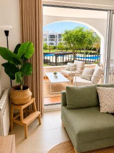 a living room with a couch and a plant at Casa Lilo - Renovated 2-Bed Apartment with Pool View - La Torre Golf Resort in Torre-Pacheco