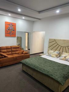 a bedroom with a bed and a couch at CZ Apartments in Bardon Yana