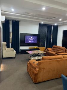 a living room with couches and a flat screen tv at CZ Apartments in Bardon Yana