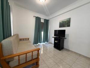 a living room with a couch and a television at Rabelo C in Armação de Pêra