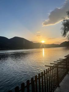 a sunset over a body of water with a fence at Lure House in Mali Zvornik
