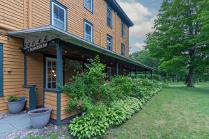 a building with a flower garden in front of it at The Woodbine Inn in Palenville