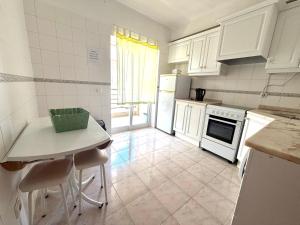 a kitchen with white appliances and a table and chairs at Rabelo C in Armação de Pêra