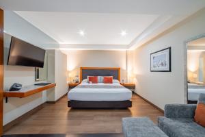 ein Hotelzimmer mit Bett und Fernseher in der Unterkunft Hotel Abastos Plaza in Mexiko-Stadt + 81 Fotos