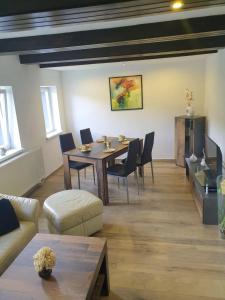 a living room with a table and chairs and a couch at Elbblick-kleine-Wohnung-mit-Terrasse in Gollhofen