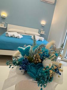a bedroom with a bed with a bouquet of flowers at B&B La Perla di Praia in Praia a Mare
