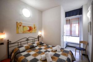 a bedroom with a bed with a checkered blanket at Albergo Al Carugio in Monterosso al Mare