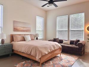 a bedroom with a bed and a couch and windows at Houston House Downtown Stays - Free Parking in Houston