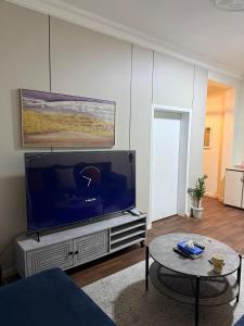 a living room with a large flat screen tv at شقق الفيصل in Al Khobar +3 photos