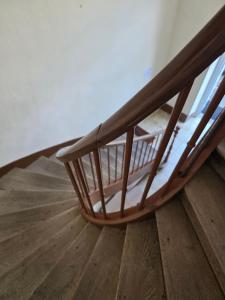 a wooden staircase with a glass railing on a wooden floor at Maison Lanty in Lanty