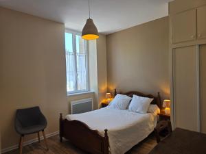 a bedroom with a bed and a chair and a window at Maison Lanty in Lanty
