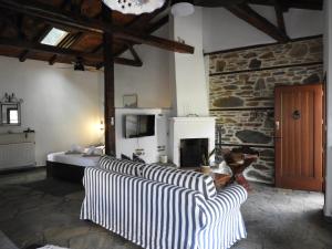 a living room with several couches and a fireplace at Olivia traditional stone house in Nikiti