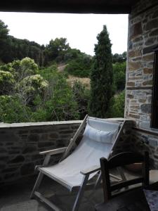 a hammock on the back porch of a house at Olivia traditional stone house in Nikiti