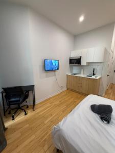 a bedroom with a bed and a desk and a television at Downtown Studio for 2 with Free private parking in Montreal