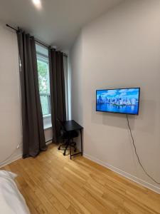 a bedroom with a flat screen tv on the wall at Downtown Studio for 2 with Free private parking in Montreal