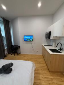 a bedroom with a bed and a tv on the wall at Downtown Studio for 2 with Free private parking in Montreal