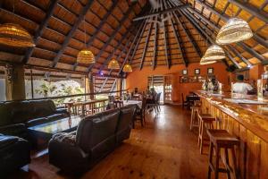 a restaurant with a bar with chairs and tables at Ndumu Safari Resorts in Jozini