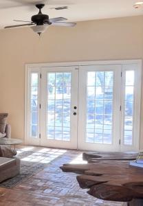 a living room with french doors and a ceiling fan at Steps from beach with open fire pit in Gulfport