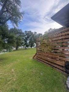 a wooden fence in a field with trees in the background at Steps from beach with open fire pit in Gulfport