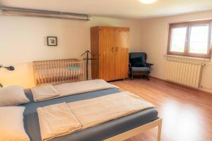 a bedroom with two beds and a chair at Mediterranean Family design in Izola