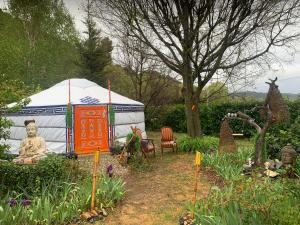 a yurt with a statue of a buddha in a garden at Yourte piscine jacuzzi in Gréoux-les-Bains