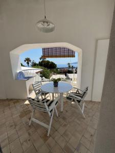a table and chairs on a patio with a view of the ocean at Il Portico sul mare in Santa Marina Salina