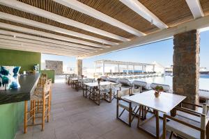 a restaurant with tables and chairs on a patio at Porto Mykonos in Mikonos