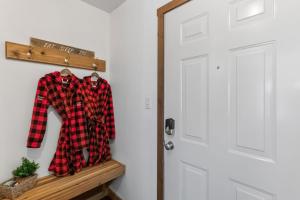 a red and black plaid shirt on a wooden shelf next to a door at Trailside Escape a Ski-In Ski-Out Studio in SilverStar in Vernon