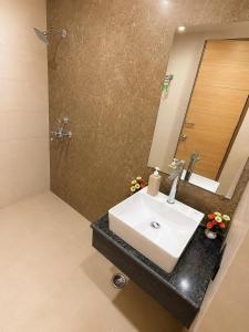a bathroom with a sink and a mirror at Elvora Stay's - Studio with Jacuzzi in Ghaziabad +7 photos