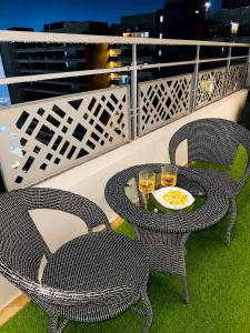 two chairs and a table with drinks on a balcony at Elvora Stay's - Studio with Jacuzzi in Ghaziabad