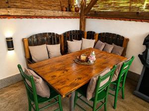 a wooden table with green chairs around it at Garden Lux Grujić Apartmani in Krivi Vir