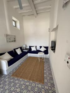 a living room with a blue couch and a table at Il Portico sul mare in Santa Marina Salina